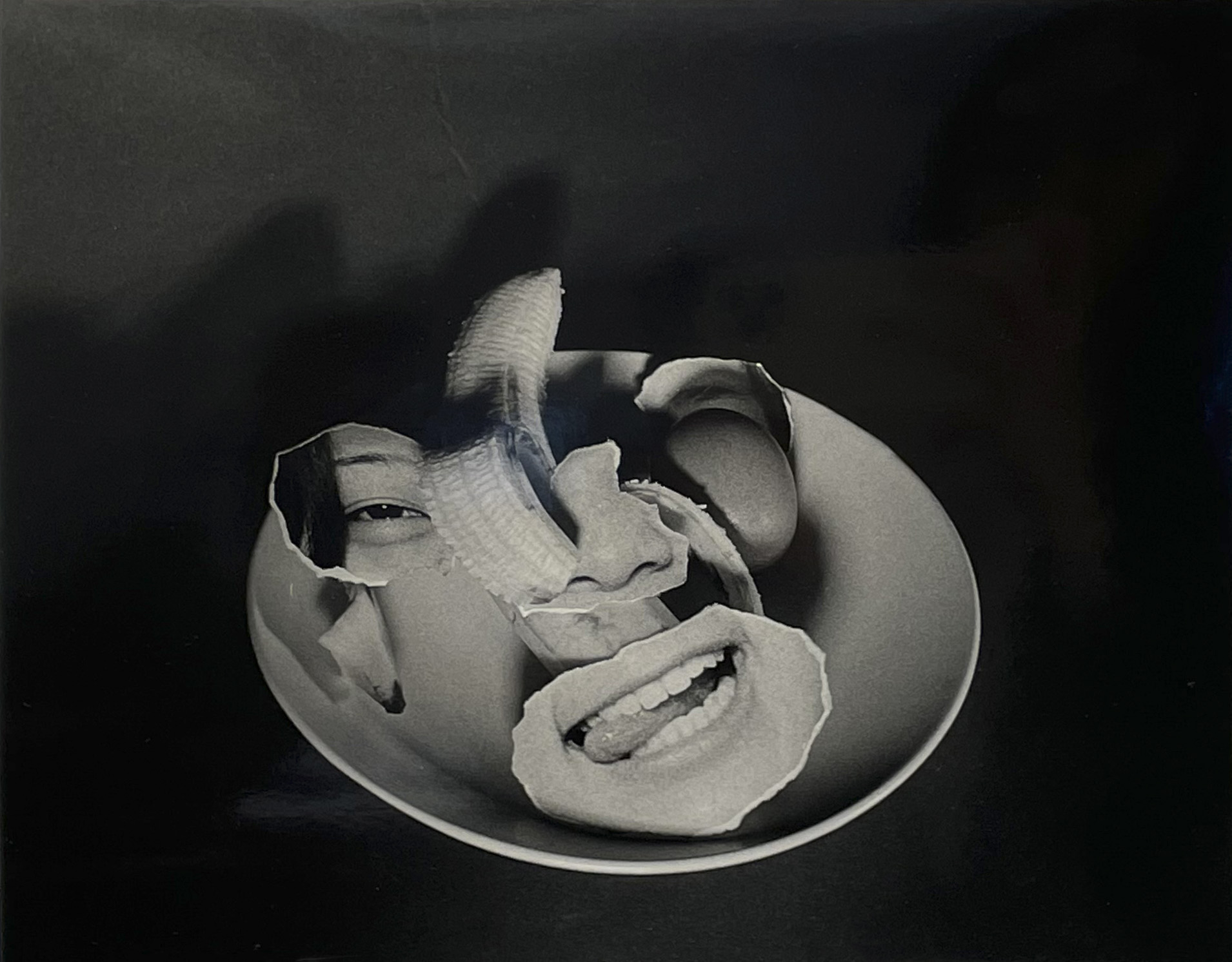 A photographic montage on a plate with a banana appears to show a face